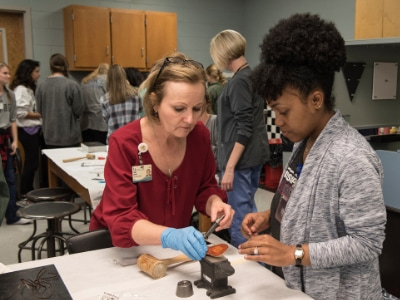 An OT student works closely with a faculty member to learn treatment skills